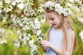 Beautiful young girl in blue dress in the garden with blosoming  apple trees. Cute girl  holding apple-tree branch Royalty Free Stock Photo