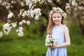 Beautiful young girl in blue dress in the garden with blosoming  apple trees. Smiling girl  having fun and enjoying Royalty Free Stock Photo