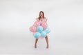 Beautiful young girl with with blue and pink balloons on the background, Joyful model. Happiness, spring, birthday party