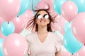 Beautiful young girl with with blue and pink balloons on the background, Joyful model. Happiness, spring, birthday party