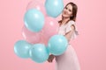 Beautiful young girl with with blue and pink balloons on the background, Joyful model. Happiness, spring, birthday party