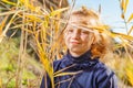 A beautiful, beautiful and young girl in a blue sweater is smiling in the reeds on the bank of the river, her hair backlit by the Royalty Free Stock Photo