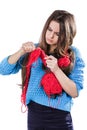 Beautiful young girl in a blue sweater standing with a red ball of yarn and knitting a scarf and Spitz. White background. Isolate. Royalty Free Stock Photo