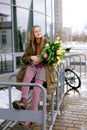 Beautiful young girl with a bouquet of white and yellow tulips in the park Royalty Free Stock Photo