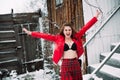 Girl in a bra, red skirt and leather jacket walks around the yard near the old building and laughs Royalty Free Stock Photo