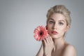 Beautiful young girl with clean skin and pink gerbera in her hand. Royalty Free Stock Photo
