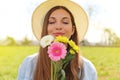 Beautiful young girl with closed eyes and hat smelling bouquet of flowers in spring time Royalty Free Stock Photo