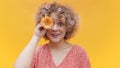 Beautiful young girl covering her eye with an orange gerbera daisy flower Royalty Free Stock Photo