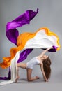 Beautiful young girl dancing. Flowing fabric.