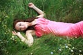 Beautiful young girl dreams, lying on the meadow