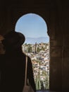 A beautiful young girl in a dress and a hat looking at the Albaicin district of Granada from the window of the Alhambra palace Royalty Free Stock Photo