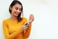 Beautiful young girl dressed in yellow, spraying perfume