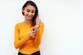 Beautiful young girl dressed in yellow, spraying perfume