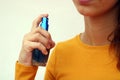 Beautiful young girl dressed in yellow, spraying perfume