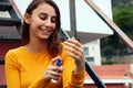 Beautiful young girl dressed in yellow, spraying perfume