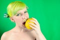 Beautiful young girl eats lemon and screws up face on green background Royalty Free Stock Photo