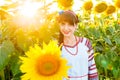 Beautiful young girl in embrodery looking to camera on sunflower Royalty Free Stock Photo