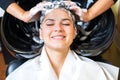 Beautiful young girl enjoying hair washing in hairdressing salon. Royalty Free Stock Photo