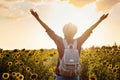 Beautiful young girl enjoying nature on the field of sunflowers at sunset Royalty Free Stock Photo