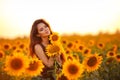 Beautiful young girl enjoying nature on the field of sunflowers at sunset. Summertime. Attractive brunette woman with long healthy Royalty Free Stock Photo