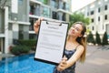 Young beautiful woman offers to sign contract. Focus on document