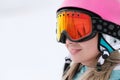 A beautiful young girl in an extreme sports suit, a hat and a helmet with a mask on the winter slope is holding alpine Royalty Free Stock Photo