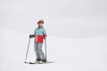 A beautiful young girl in an extreme sports suit, a hat and a helmet with a mask on the winter slope is holding alpine Royalty Free Stock Photo