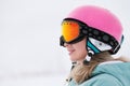 A beautiful young girl in an extreme sports suit, a hat and a helmet with a mask on the winter slope is holding alpine Royalty Free Stock Photo