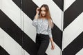 Beautiful young girl in fashionable blouse near the wall design Royalty Free Stock Photo