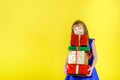 Beautiful young girl in a festive blue dress holding a lot of gifts and smiling Royalty Free Stock Photo