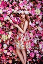 A beautiful young girl with flowers bouquet is standing near a f Royalty Free Stock Photo