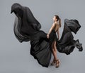beautiful young girl in flying black dress. Flowing fabric. Light black fabric flying