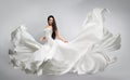 Beautiful young girl in flying white dress. Flowing fabric. Light white cloth flying Royalty Free Stock Photo