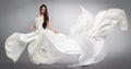 Beautiful young girl in flying white dress. Flowing fabric. Light white cloth flying Royalty Free Stock Photo