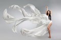 Beautiful young girl in flying white dress. Flowing fabric. Light white cloth flying Royalty Free Stock Photo