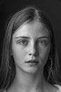 Beautiful young girl with freckles indoors on a black background, close up portrait. Black and white Royalty Free Stock Photo