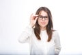 Beautiful young girl in glasses with black frame, with brown hair over shoulders and white shirt on white isolated background. Royalty Free Stock Photo