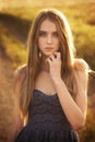 Beautiful young girl goes on a flower meadow at su Royalty Free Stock Photo