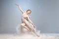 Beautiful young girl, graceful ballerina in image of angel with wings sitting on cloud isolated on white gray studio Royalty Free Stock Photo