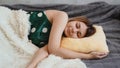 Beautiful young girl in a green nightie sleeps on a yellow pillow Royalty Free Stock Photo