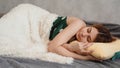 Beautiful young girl in a green nightie sleeps on a yellow pillow Royalty Free Stock Photo