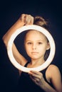 Beautiful young girl gymnast holding a glowing circle Royalty Free Stock Photo