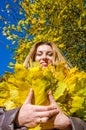 The beautiful young girl a happy woman smiling and holding a yellow maple leaves walking in autumn park Royalty Free Stock Photo