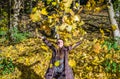 The beautiful young girl a happy woman smiling and holding a yellow maple leaves walking in autumn park Royalty Free Stock Photo