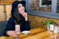 Beautiful young girl in hat drinking coffee in cafe Royalty Free Stock Photo
