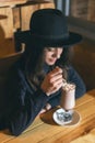 Beautiful young girl in hat drinking coffee in cafe Royalty Free Stock Photo