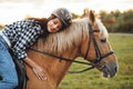 Beautiful young girl with her horse at sunset