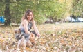 Beautiful young girl with her Yorkshire terrier dog puppy enjoying and playing in the autumn day in the park selective focus Royalty Free Stock Photo