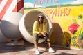 Beautiful young girl in hipster clothes , sunglasses , hat resting in a round chair Royalty Free Stock Photo