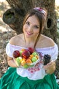 Beautiful young girl holding a plate with fruits and a glass of currant Royalty Free Stock Photo